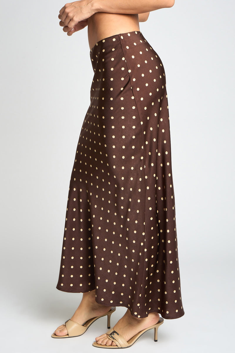 Brown polka dot pants worn by a person on a white background
