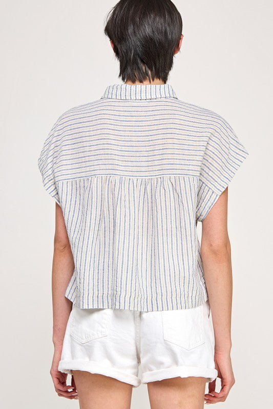 Woman wearing a striped button down blouse against a white background