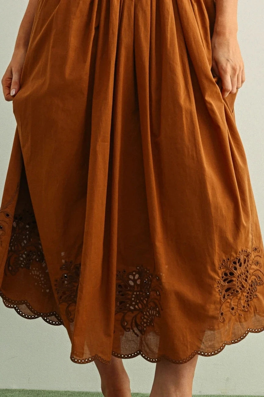 Brown dress with lace details on a plain background