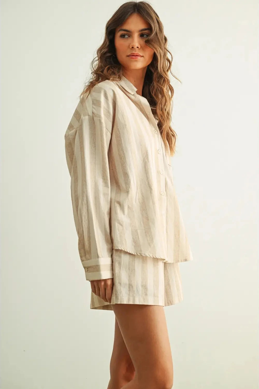 Woman wearing a beige layered outfit on a light background