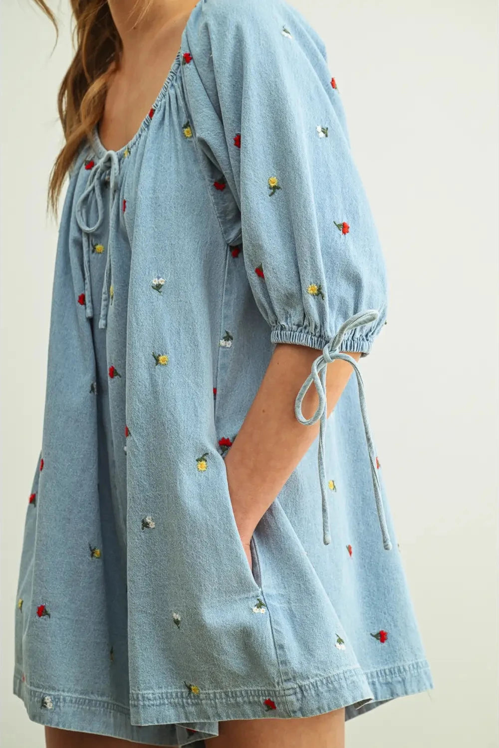Light blue dress with colorful embellishments on a plain background