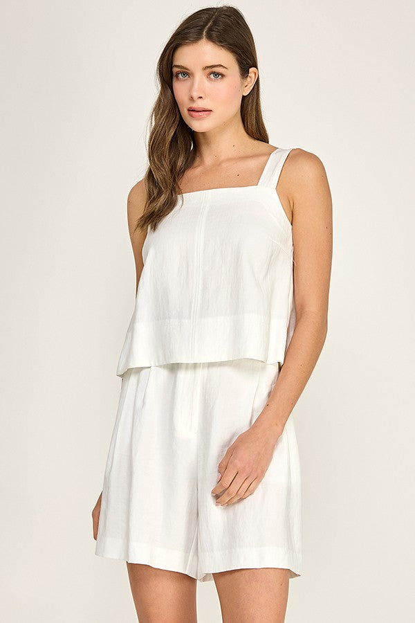 Woman wearing a white dress against a plain background