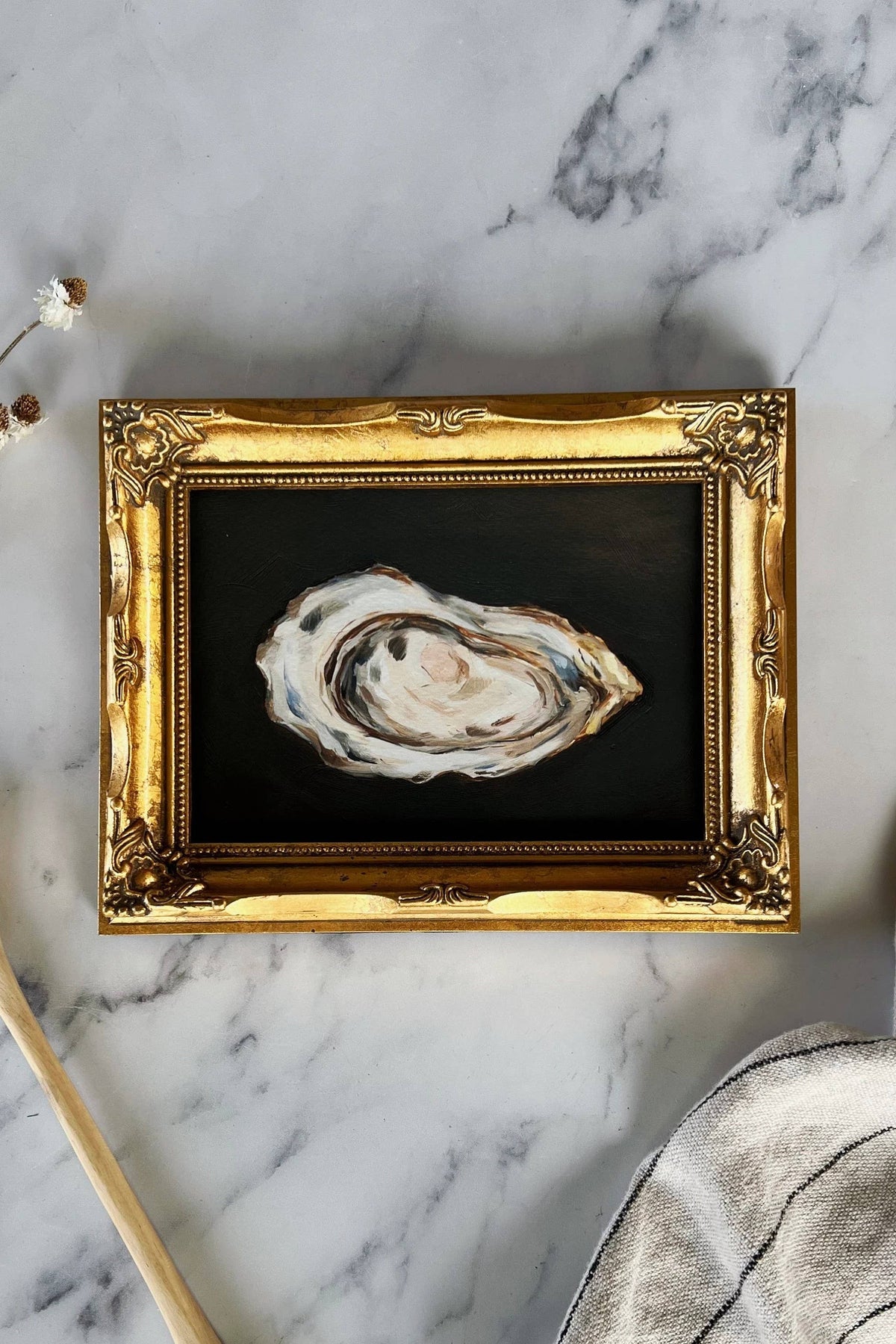 A framed Giclée print of an oyster on a marble surface.