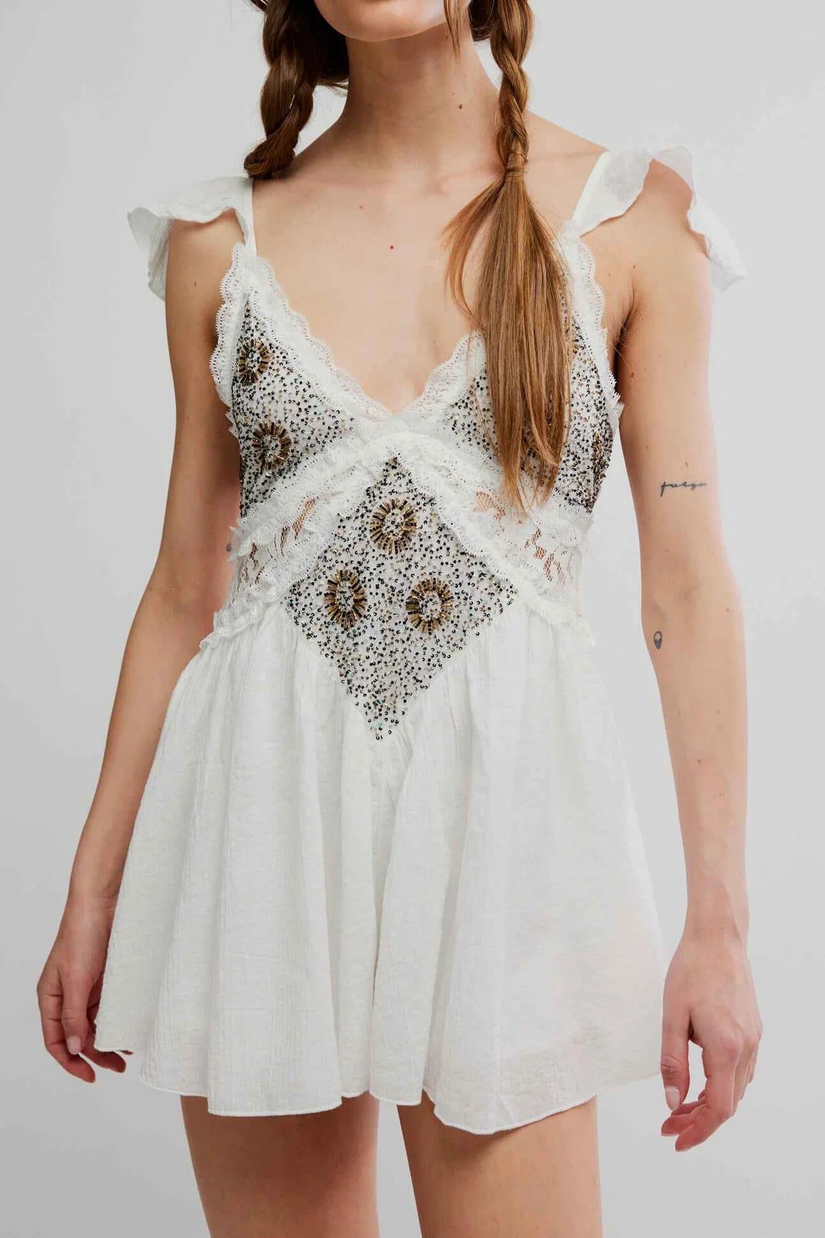 White lace dress with black floral patterns on a plain background