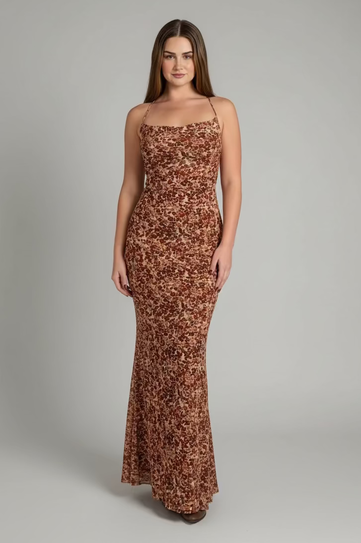 Woman wearing a brown floral dress against a gray background