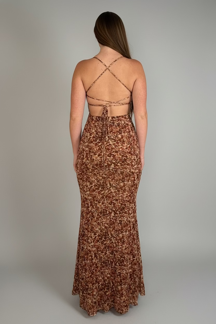 Person wearing a floral dress standing in a studio. Criss cross straps.