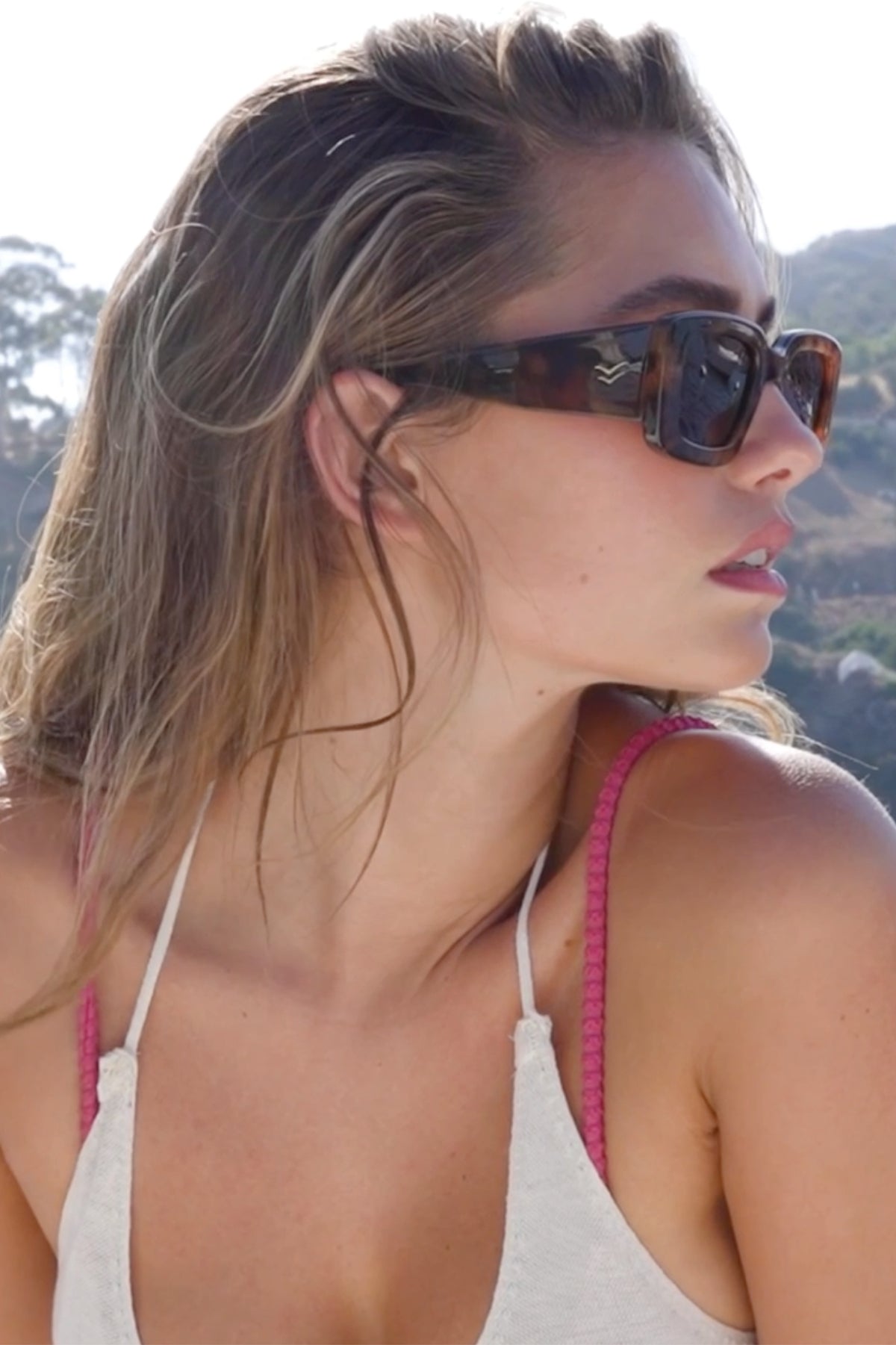 Woman wearing oversized brown/tort sunglasses.