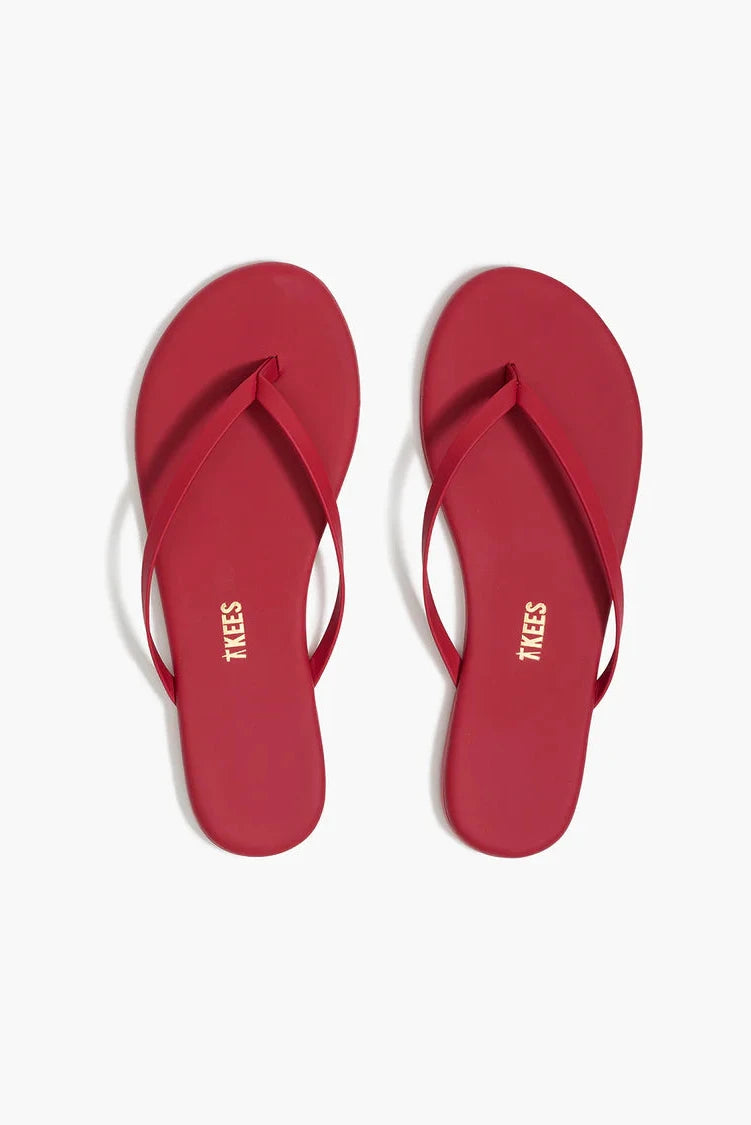 Red flip-flops with 'Tkees' branding on a white background