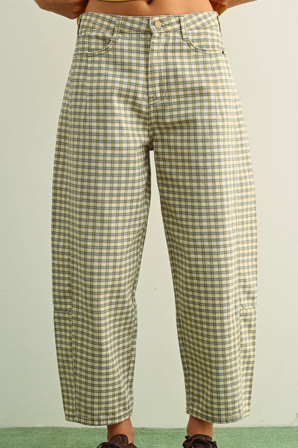 Green and white checkered pants worn by a person on a green floor.