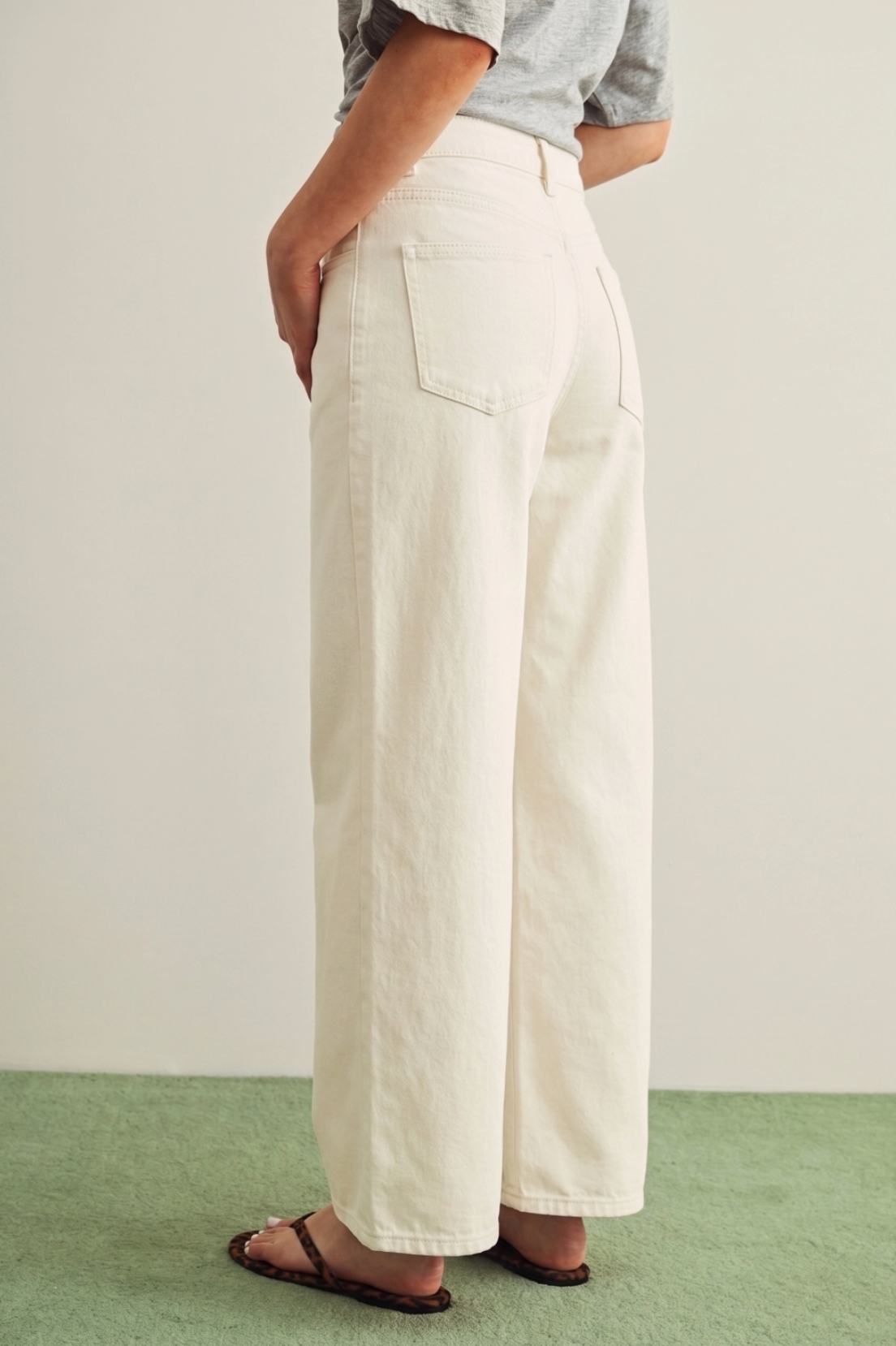 Person wearing white wide-leg pants on a plain background