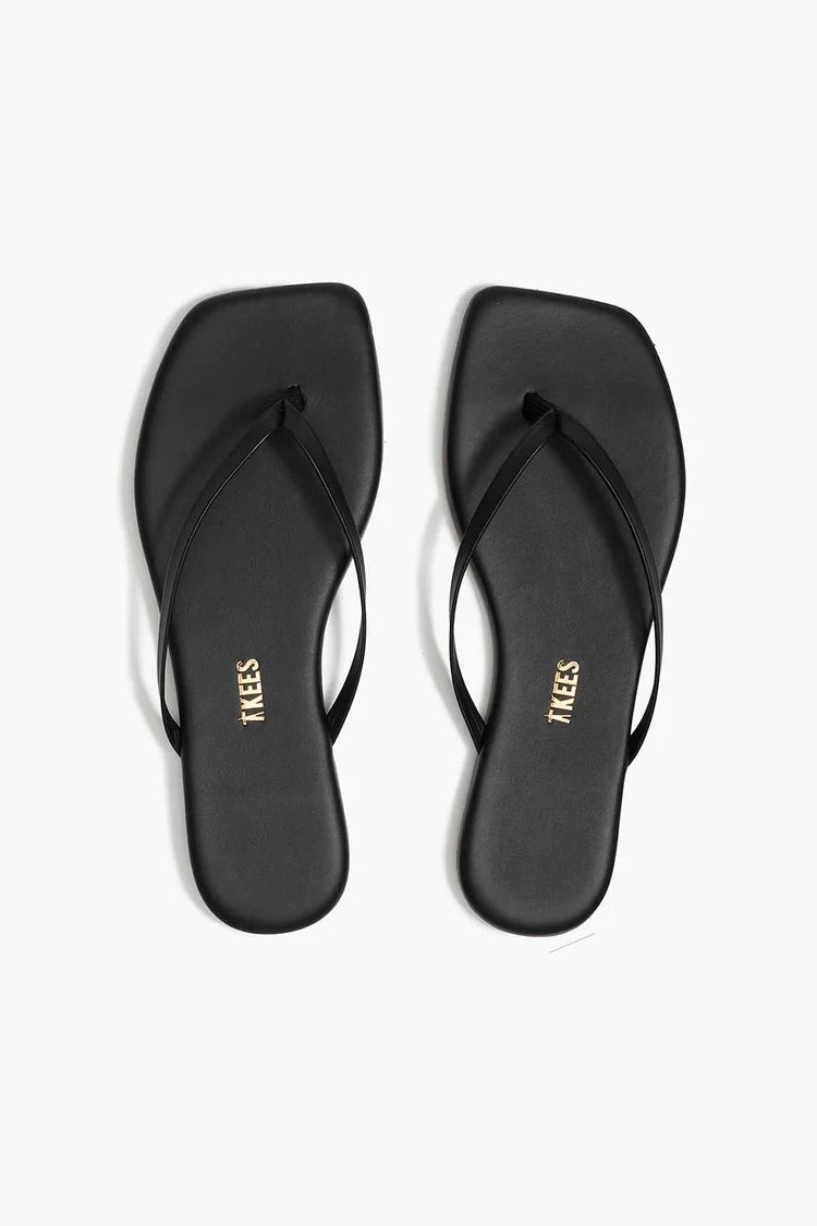 Black flip-flops with 'TKEES' branding on a white background