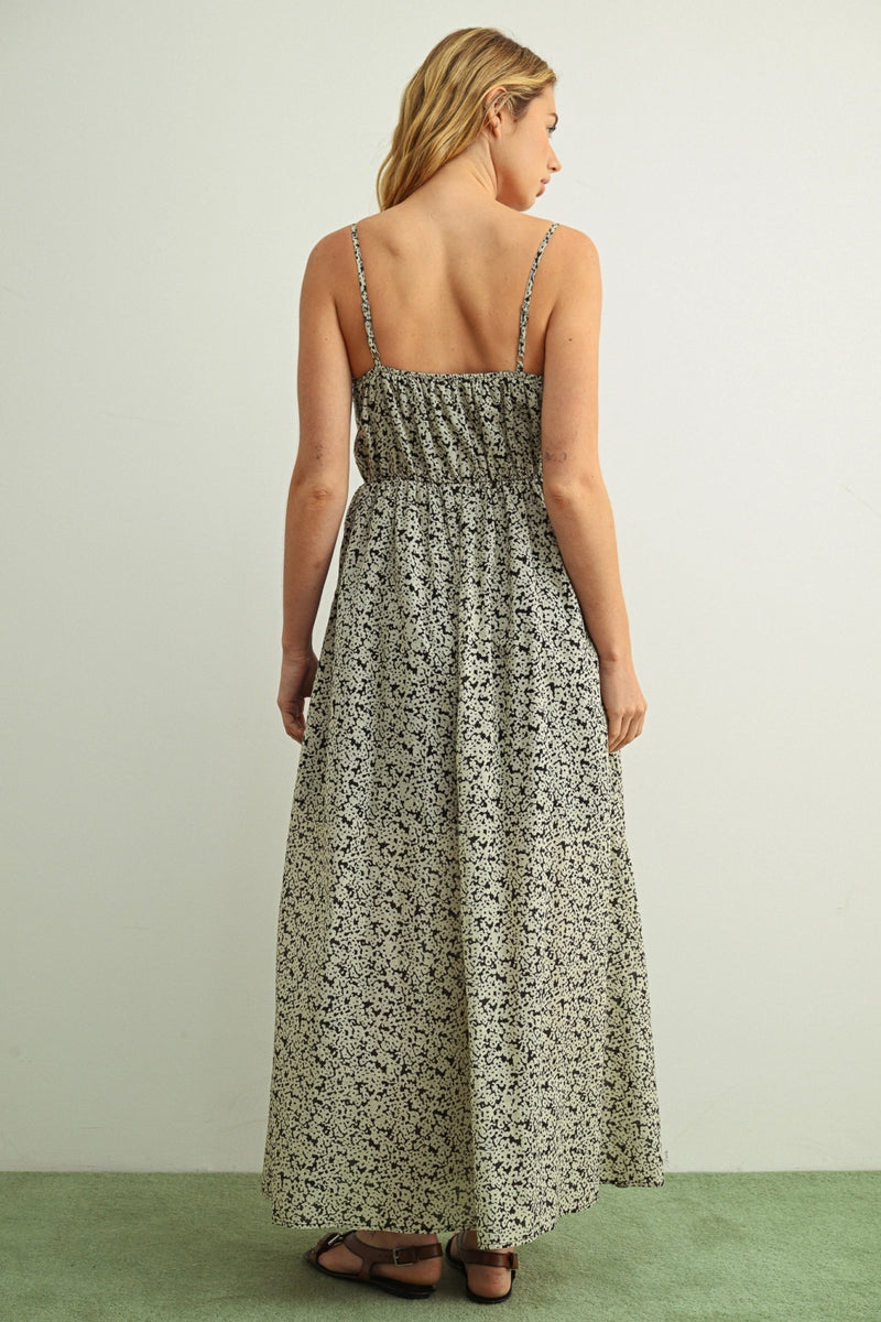 Woman wearing a floral dress with thin straps on a plain background