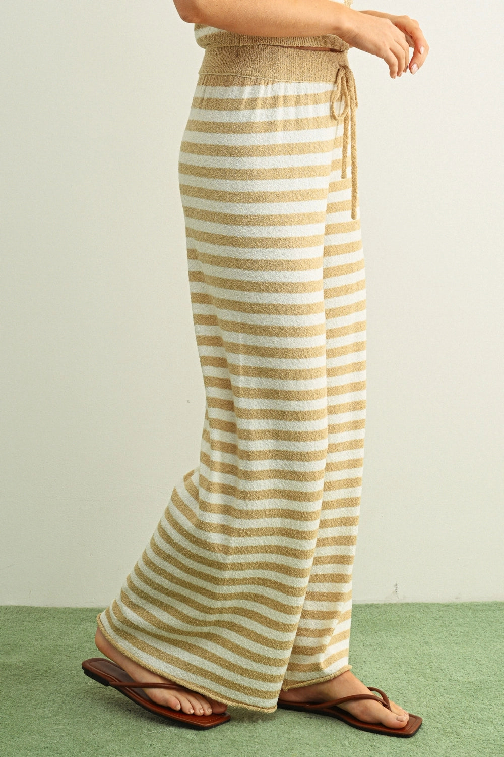 Striped pants worn by a person on a green and white background