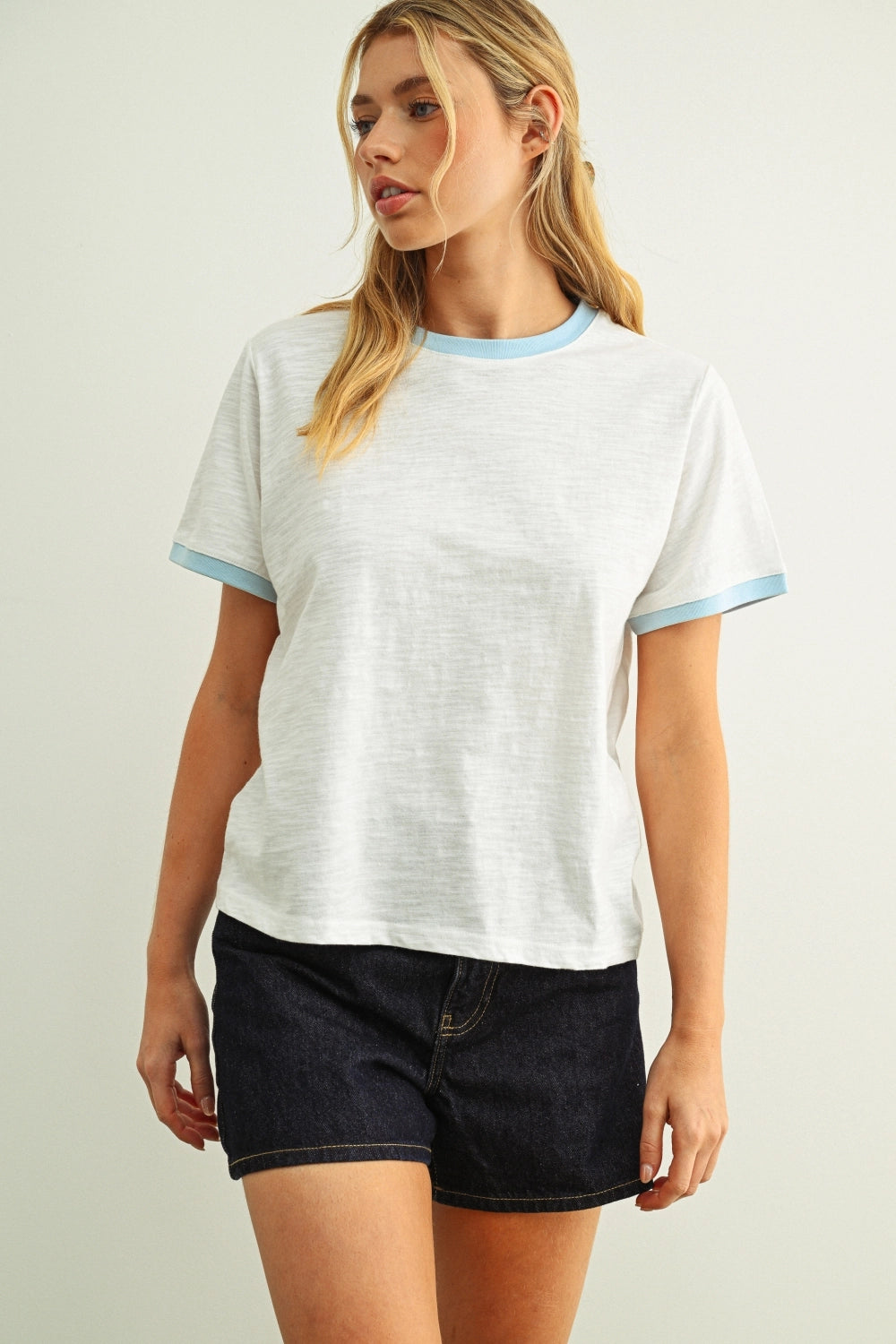 Woman modeling a white tee with a blue collar