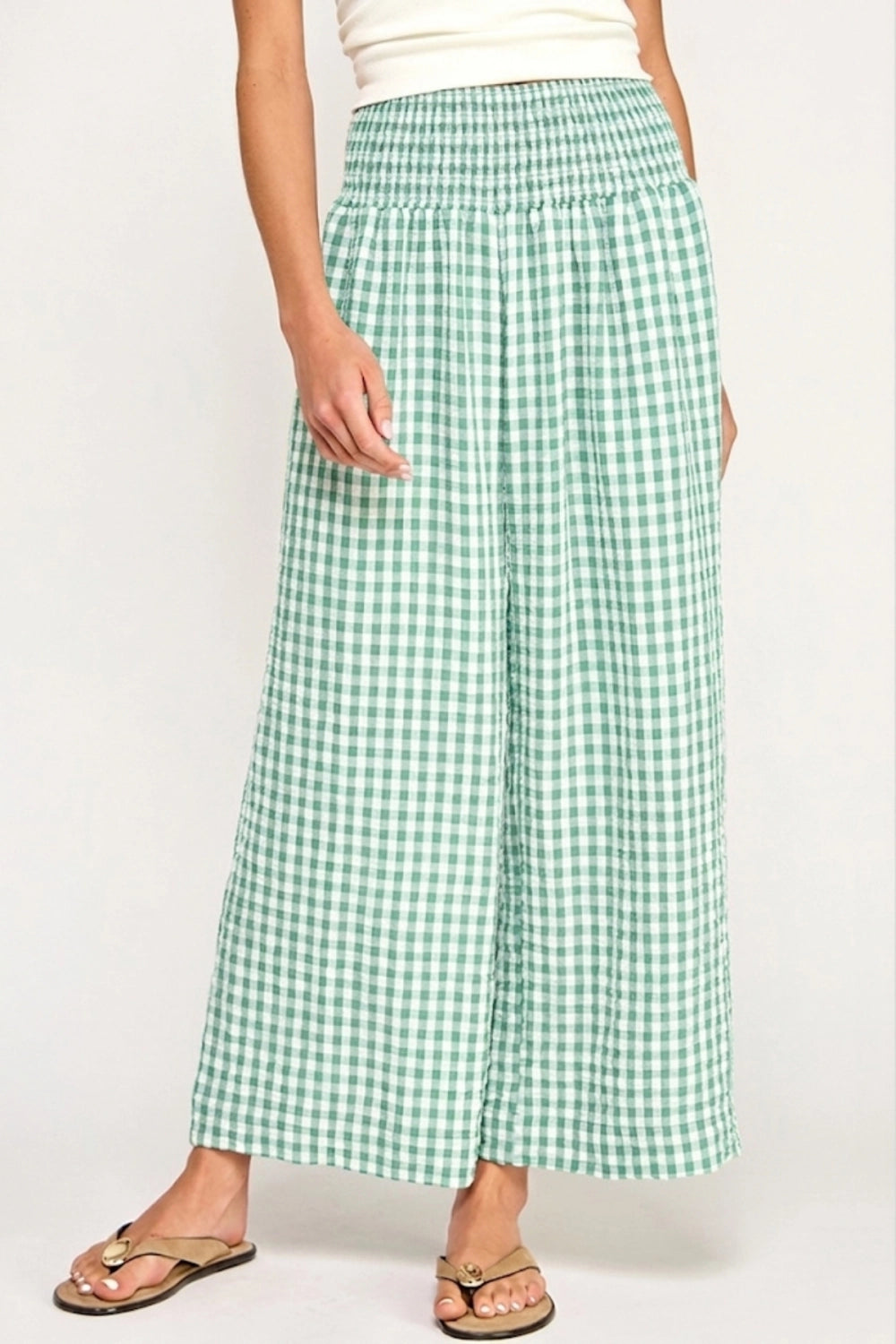 Green checkered pants worn by a person on a white background
