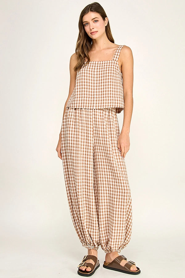 Woman wearing a checkered jumpsuit on a white background