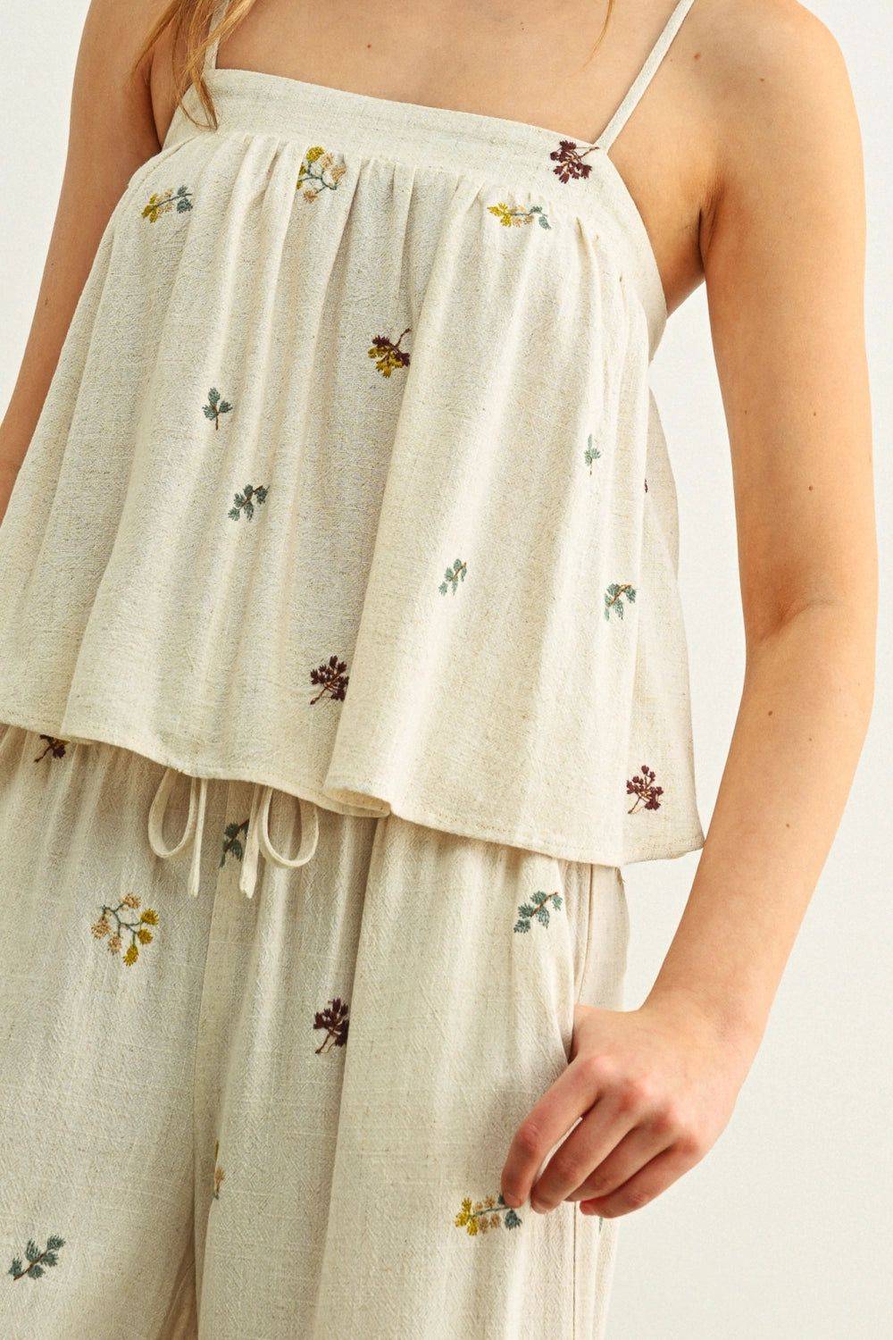 Beige embroidered top and pants set on a white background
