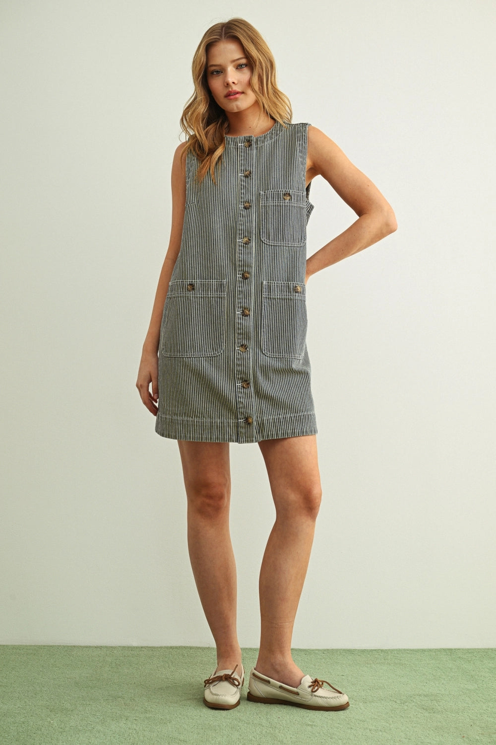 Woman wearing a denim dress on a plain background