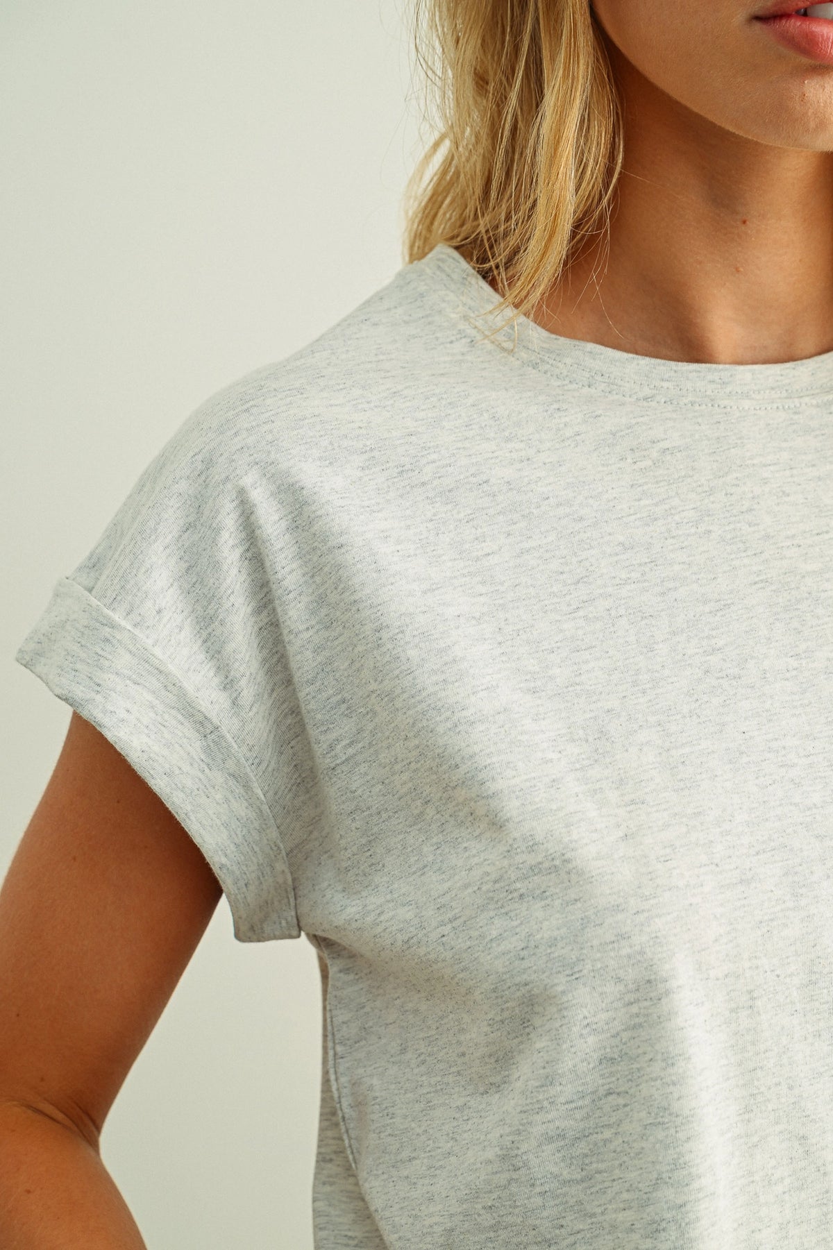 Person wearing a plain gray t-shirt against a neutral background