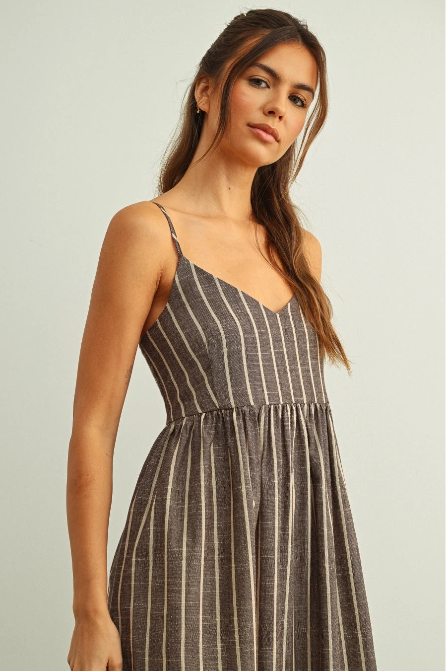 Woman wearing a striped dress against a plain background