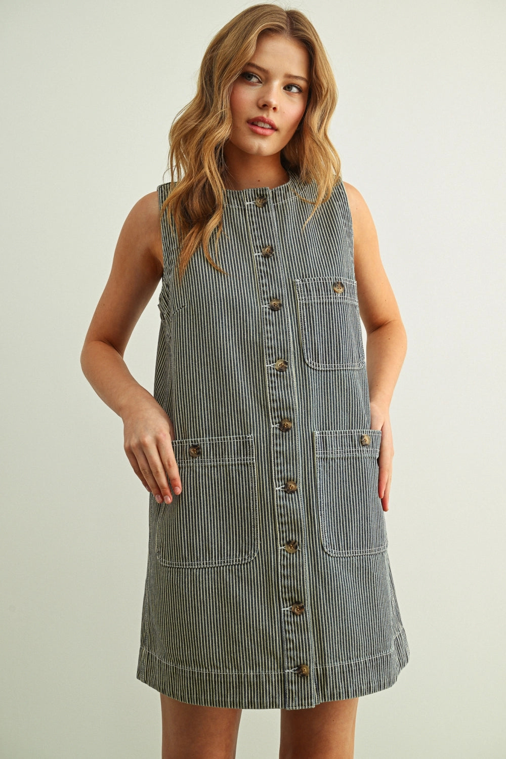 Woman wearing a denim dress with a plain background