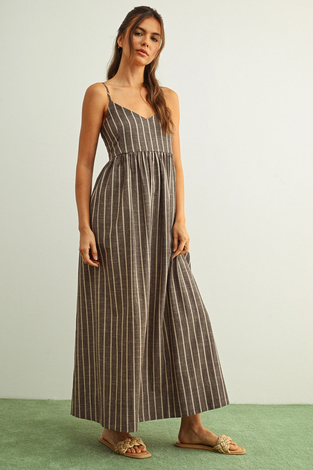 Woman wearing a striped dress on a plain background
