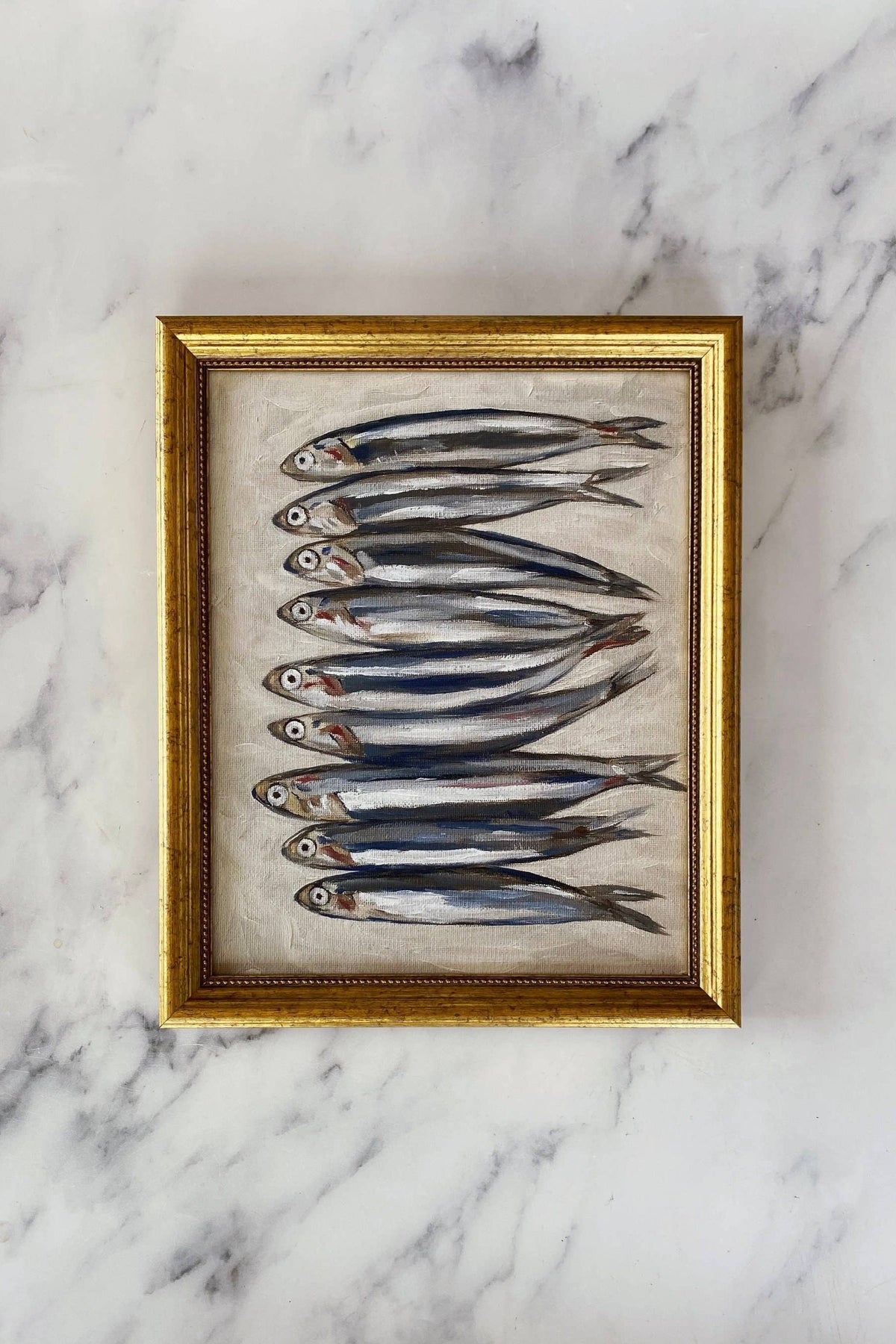 Framed artwork of fish on a marble surface