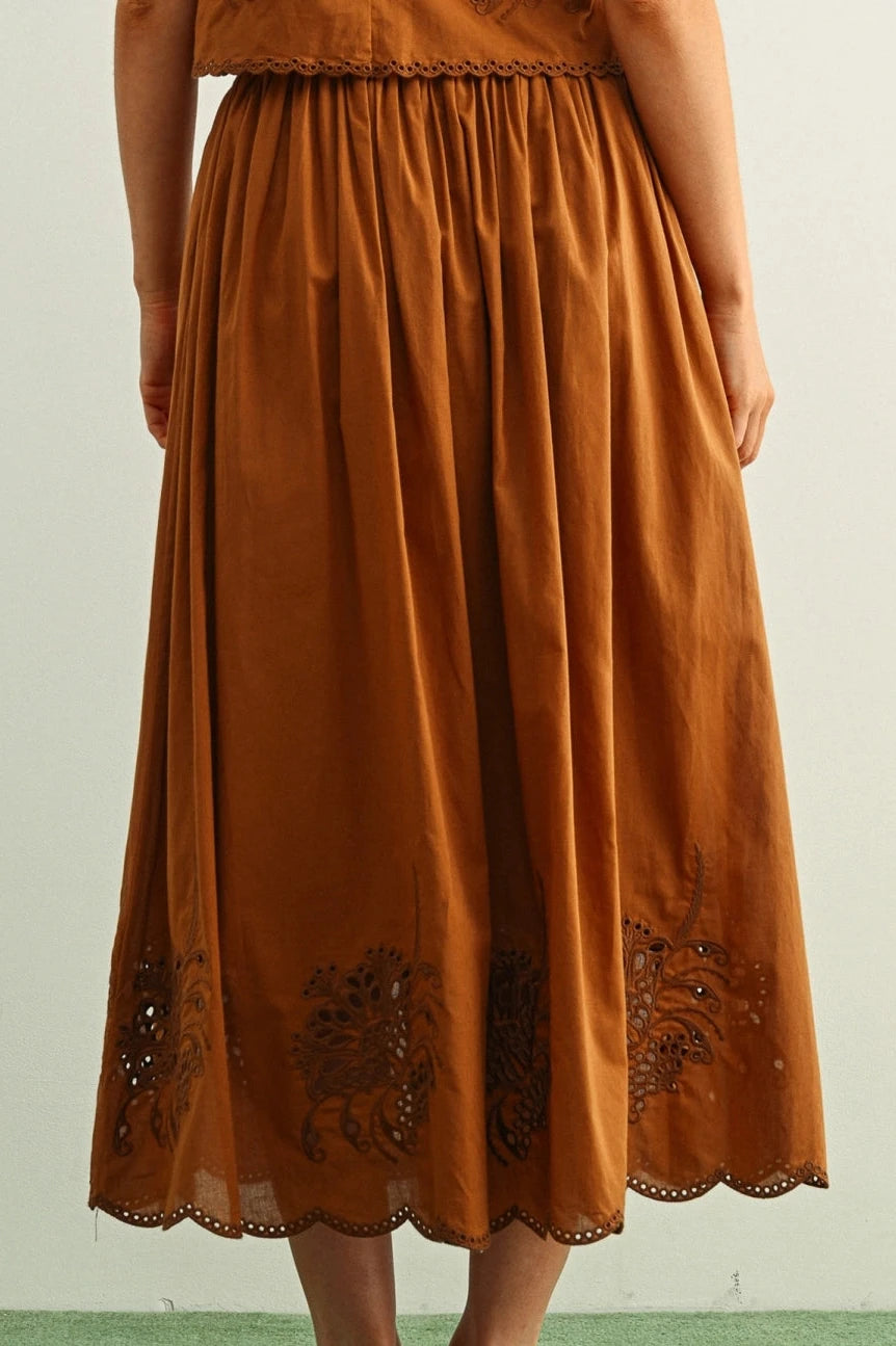 Brown dress with floral embroidery on a plain background