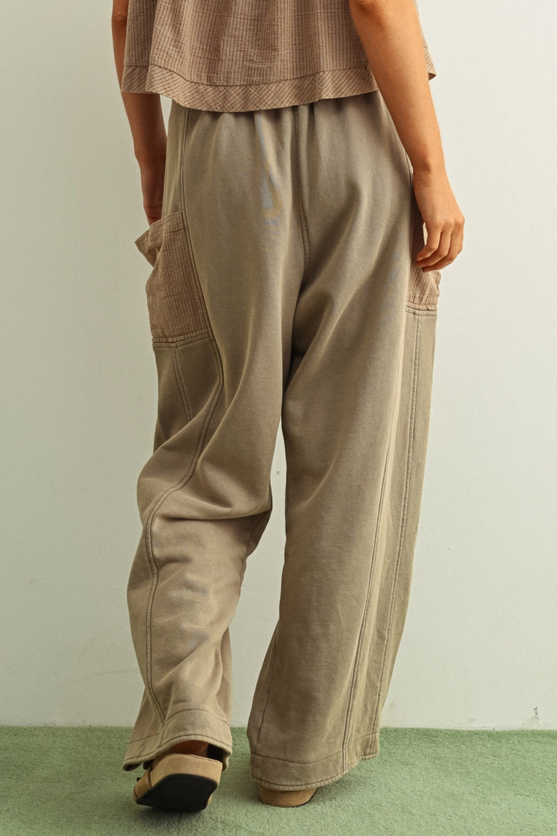 Person wearing beige pants and a matching top on a plain background