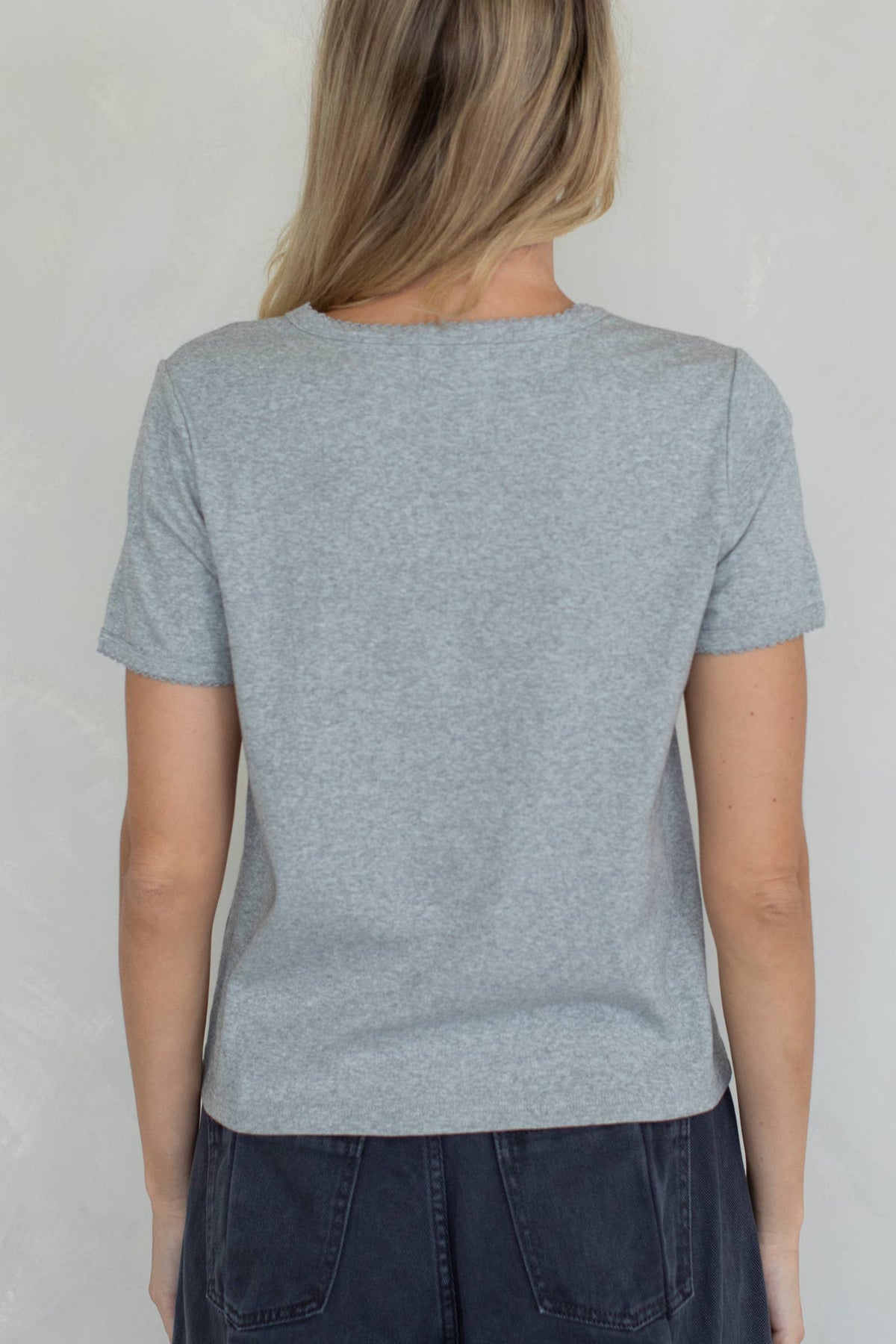 Person wearing a light gray t-shirt against a plain background