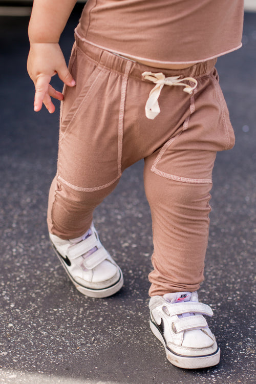 Light brown pants with visible pockets and a drawstring.